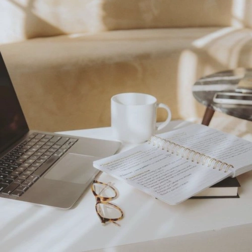 Sesión de asesoría online de decoración con portátil, libreta y materiales de trabajo